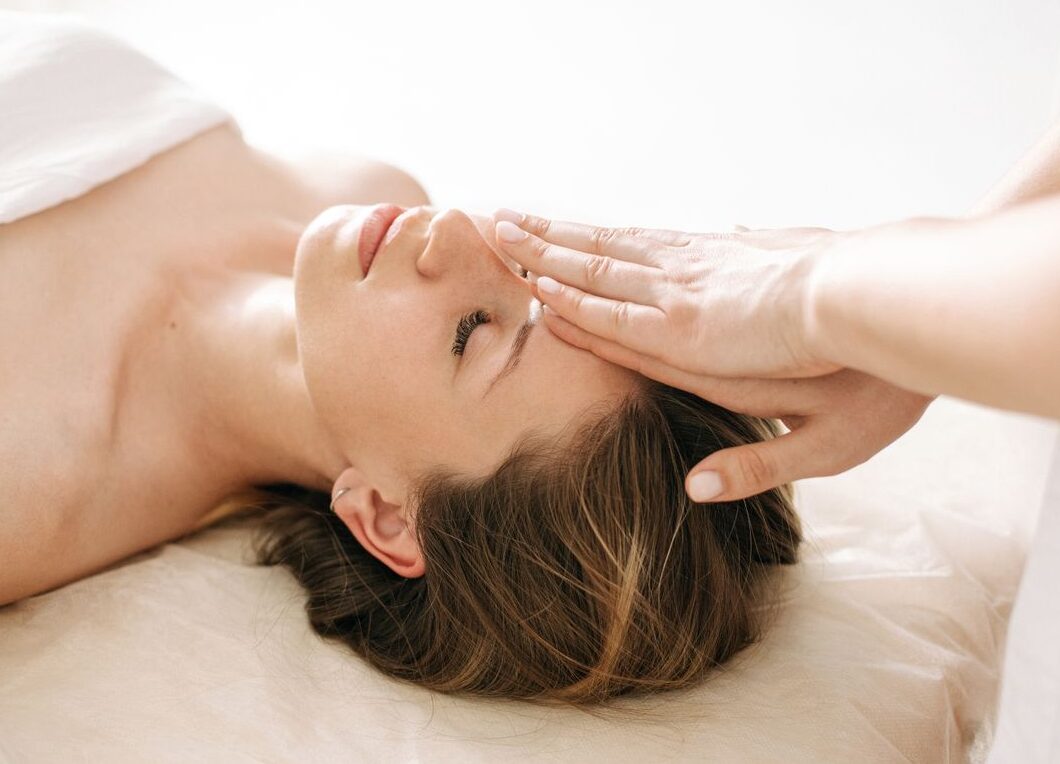 Woman enjoying a peaceful head massage in a serene spa environment.